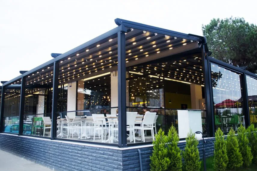 Camla çevrelenmiş aydınlatmalı pergola alanı